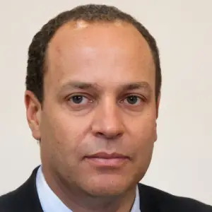 Professional headshot of a middle-aged man in a suit jacket for corporate profile
